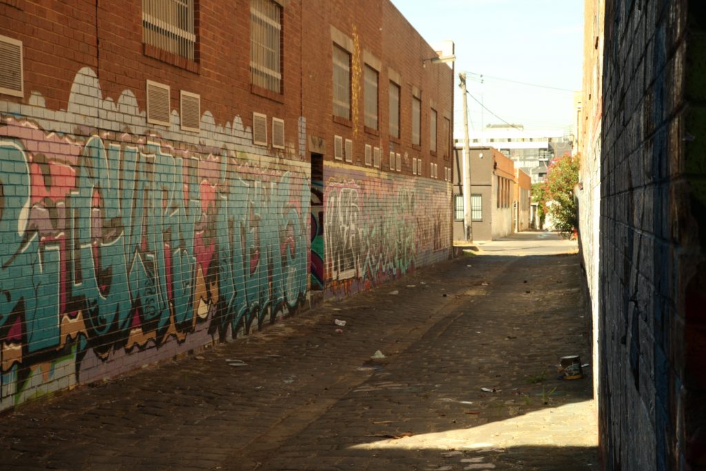 Image of an empty alleyway with graffiti on the walls